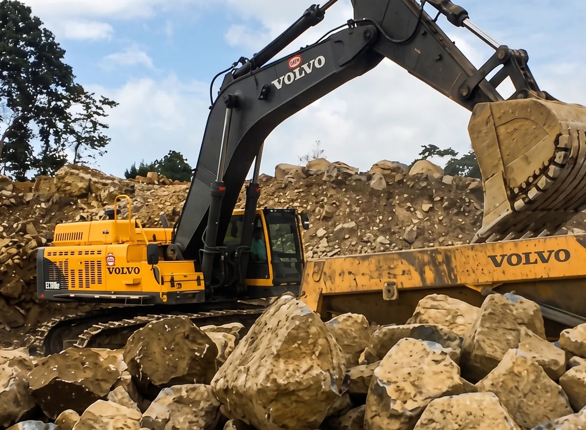 Excavator loading blocks of sound rock.